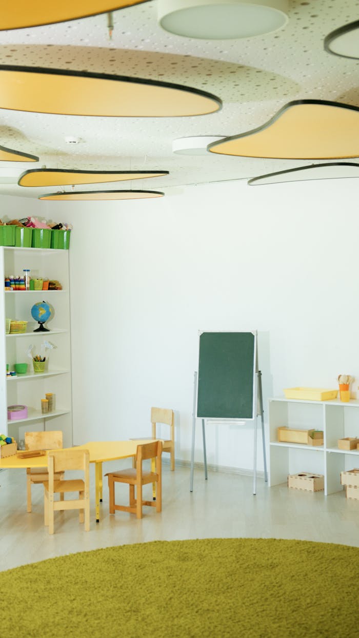 who-we-are Bright, empty classroom with wooden furniture and creative ceiling design.